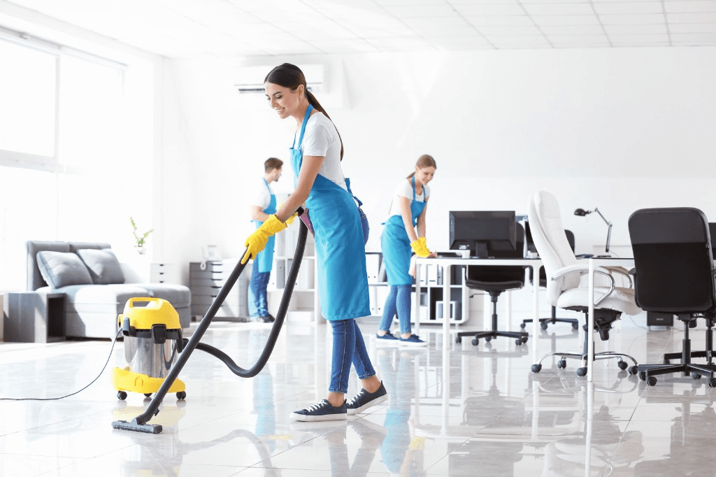 Cleaning crew vacuuming and wiping down a modern office